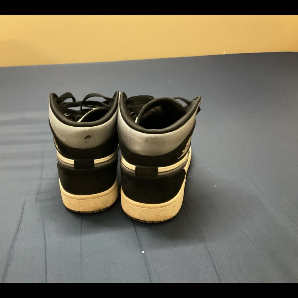 Nike Air Jordan 1s in the colors white, black and grey. It’s in a US size 8.5